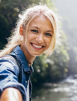 Smiling young woman by a river