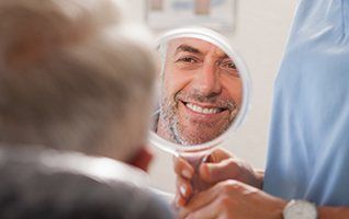 Man looking at smile in mirror